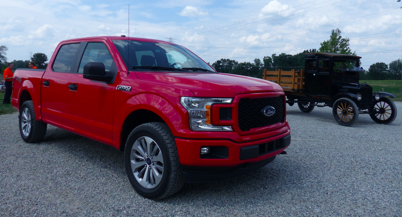 A new F-150 next to a Ford Model TT, Ford’s first “purpose-built” pickup, which launched 100 years ago.
